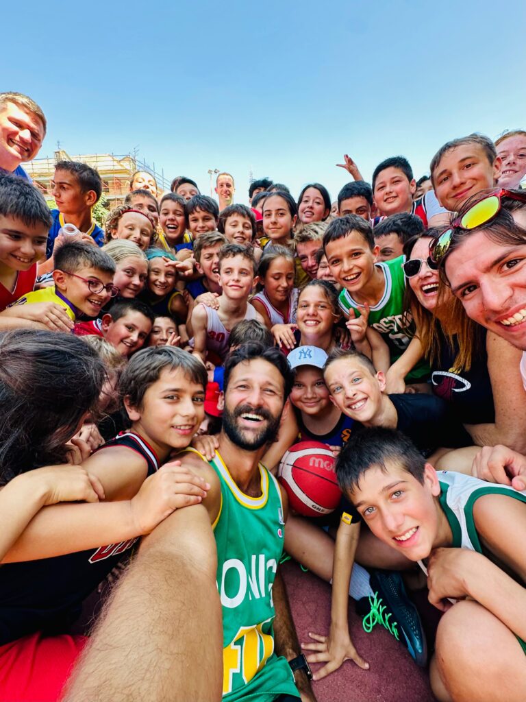 Coach Gabriel Andrade surrounded by young players at an Always Basketball International camp in Italy