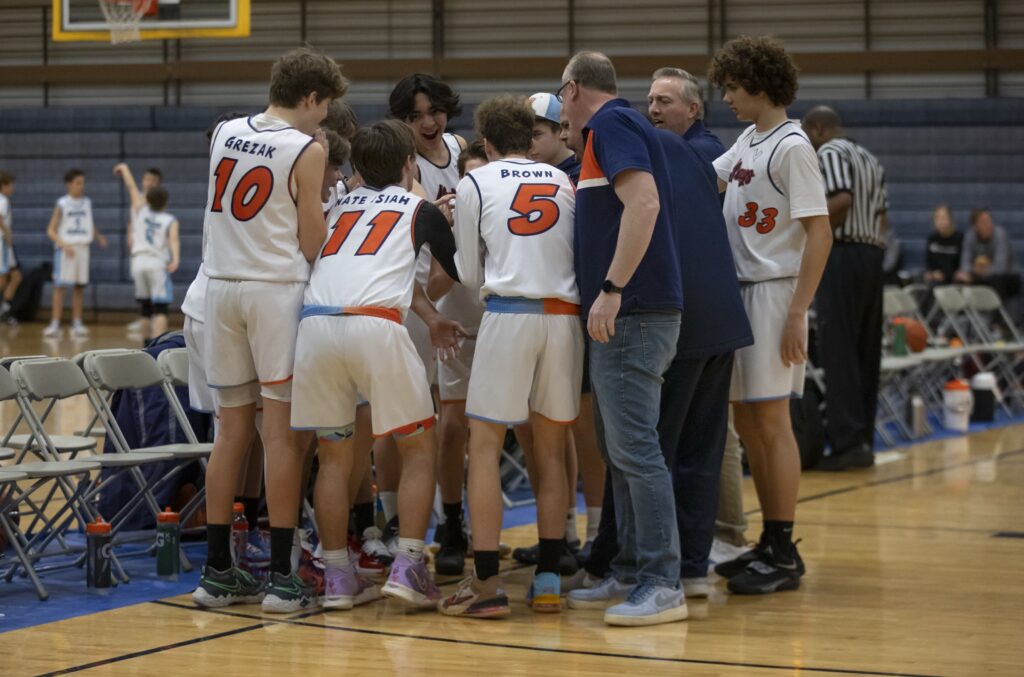 Always Basketball boys basketball team huddle during a game