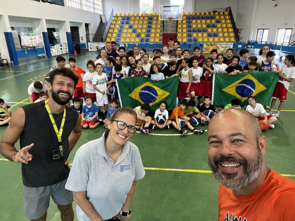 Players and coaches at an Always Basketball International camp with Brazilian flags