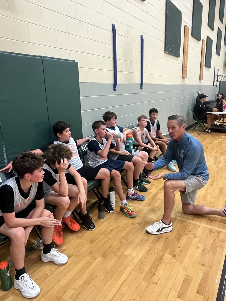 Coach Pelon talking with Always Basketball boys players during a timeout.