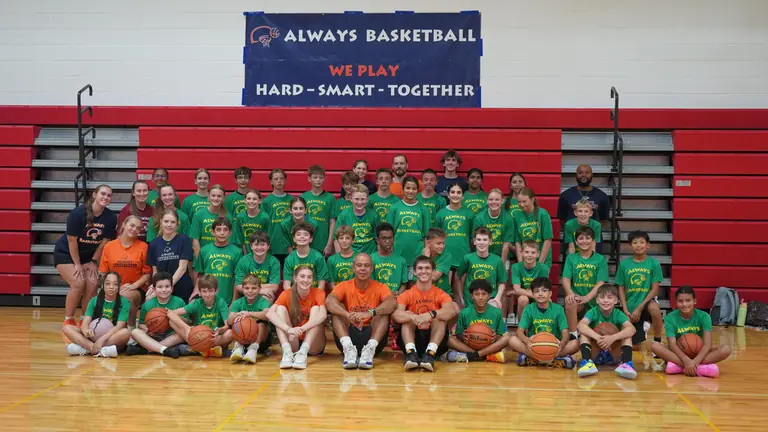 Always Basketball youth summer camp participants and coaches posing together in a gym